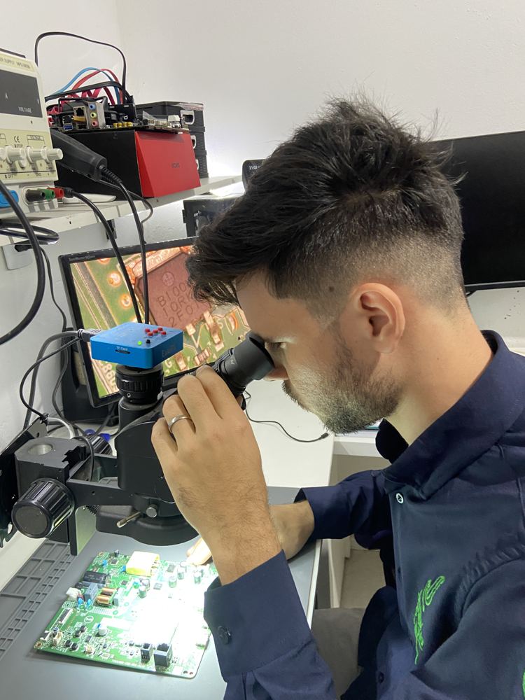 Joade na bancada analisando um equipamento